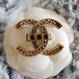Chanel Large gold tone brooch with black pearls.